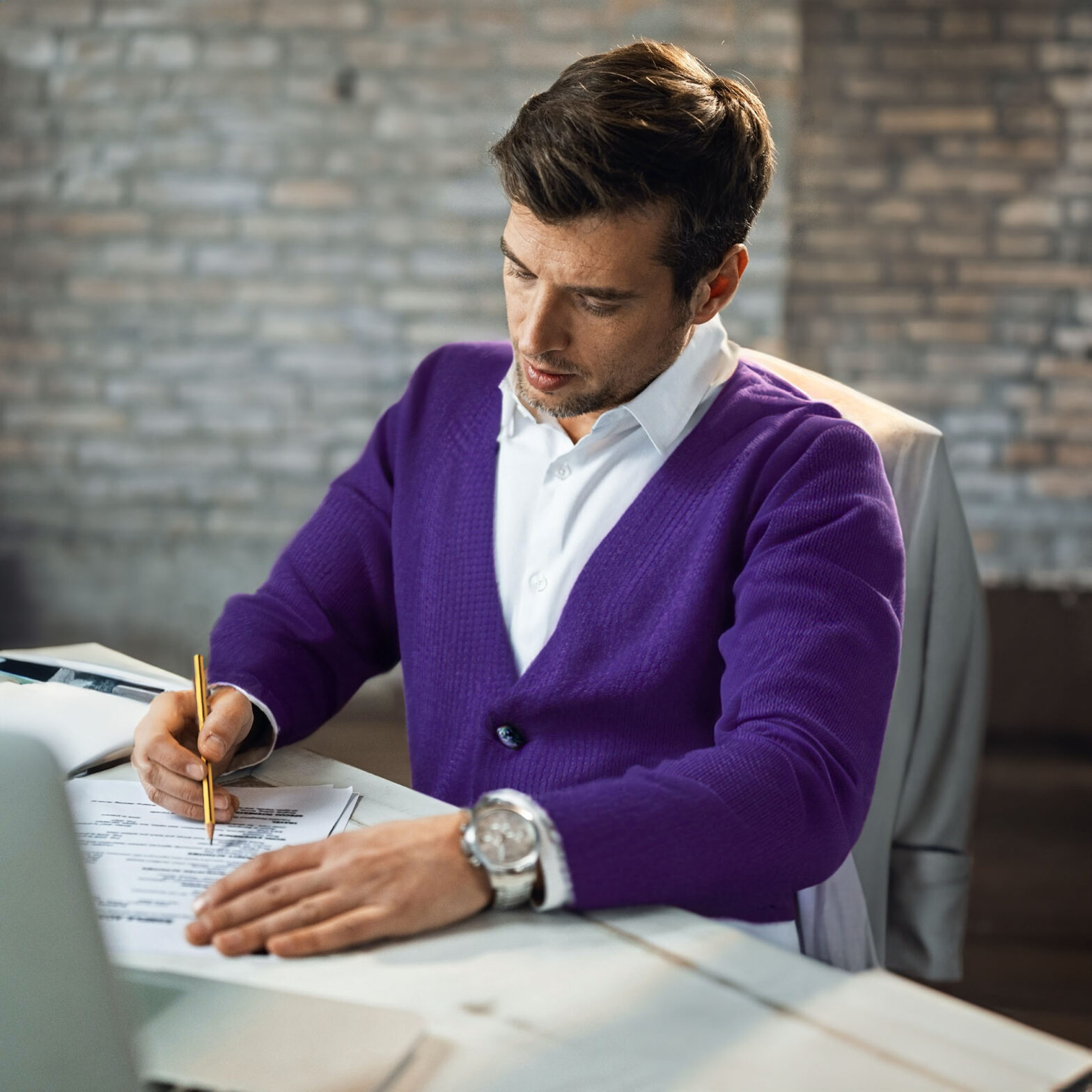 Realtor sitting at a desk signing a document.