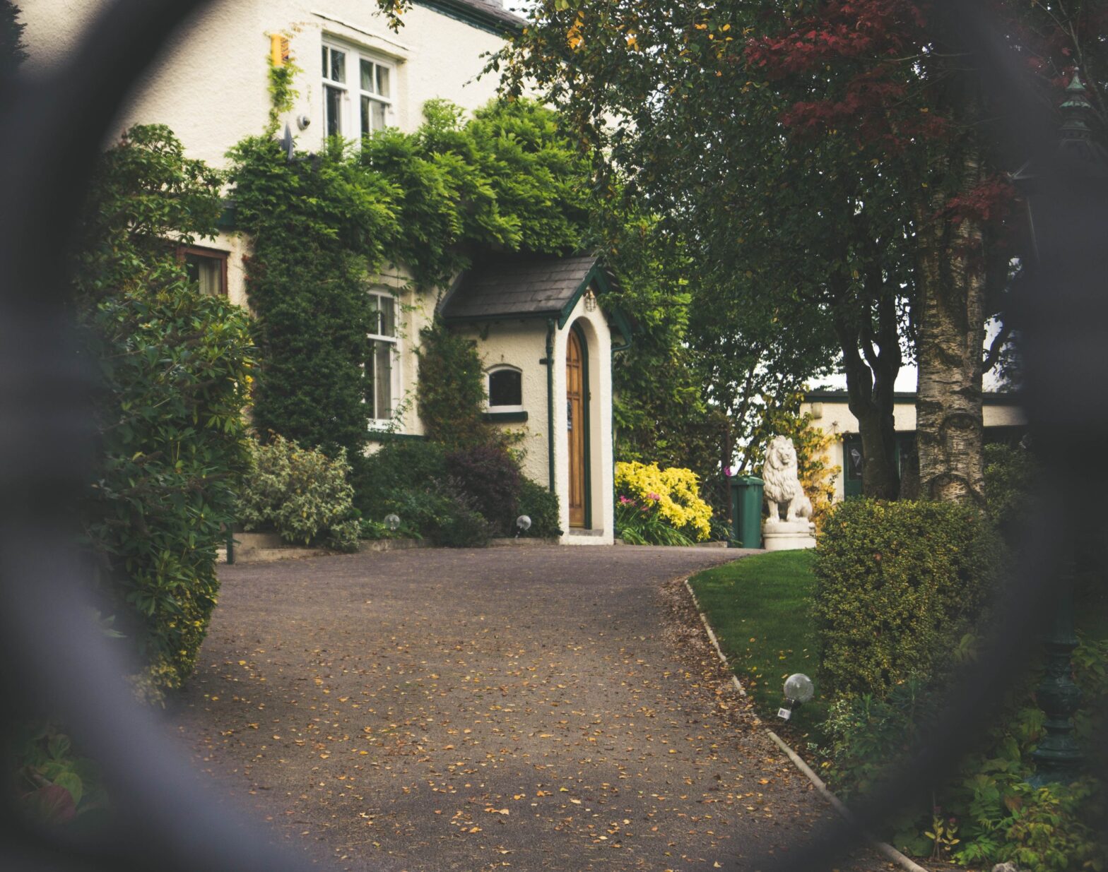 View of a house through the opening of a fence.