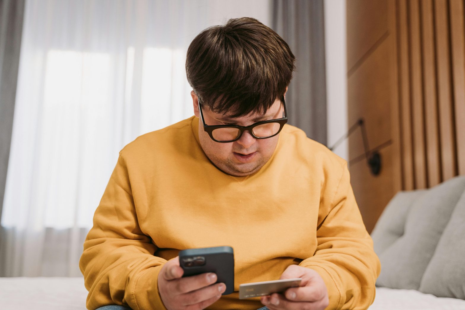 Man holding a credit card and tablet while shopping online