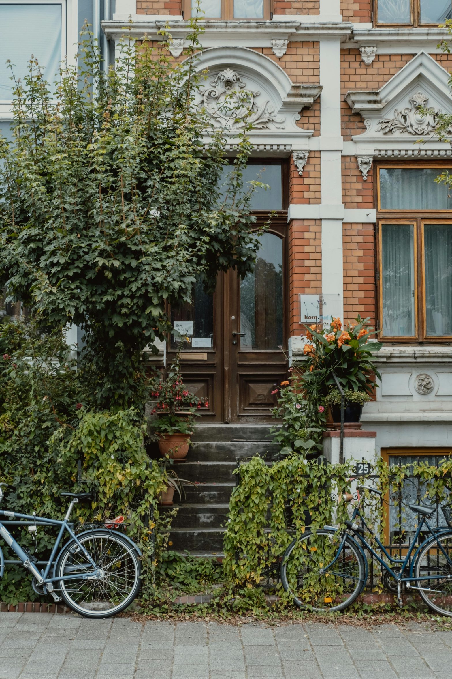 townhouse, bicycles, urban living, residential neighborhood, brick facade, parked bikes, modern lifestyle, serene setting, sustainable transportation, community living