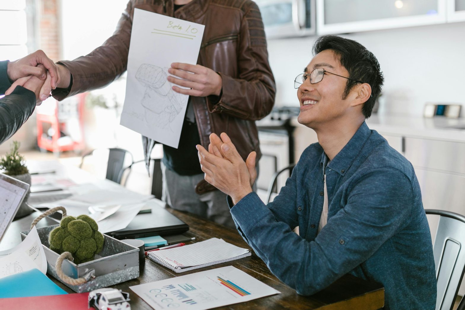 A close-up of a person clapping hands in a formal setting, symbolizing appreciation or a successful meeting.