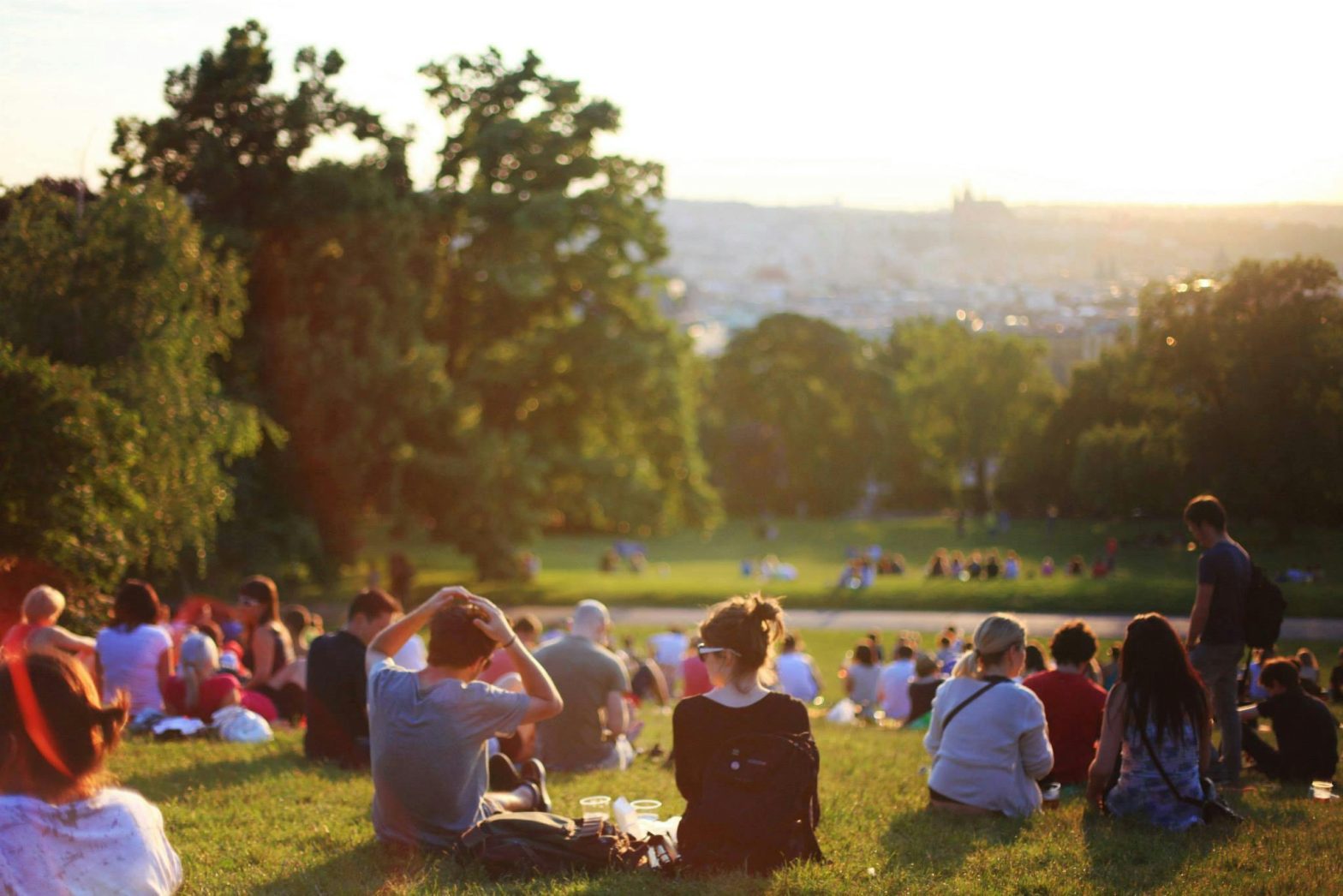 A group of people enjoying an outdoor music concert in the evening.